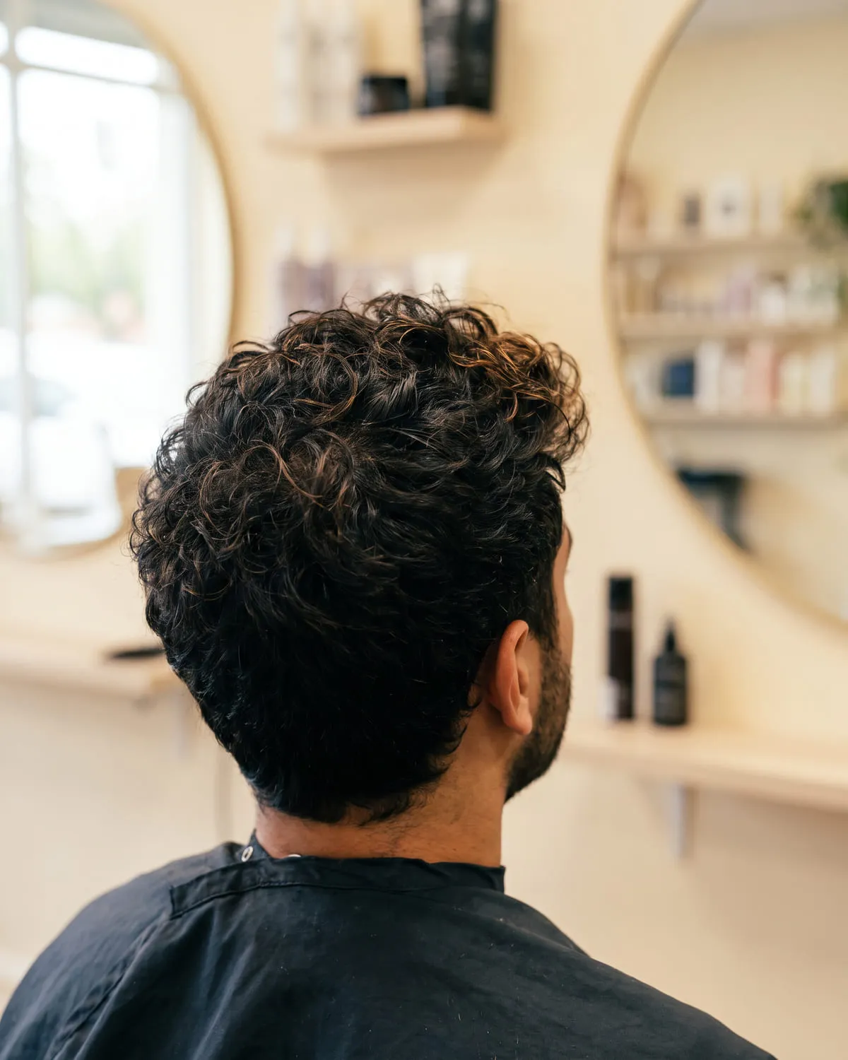 Cabello rizado oscuro con las puntas más claras en la parte superior, visto desde atrás